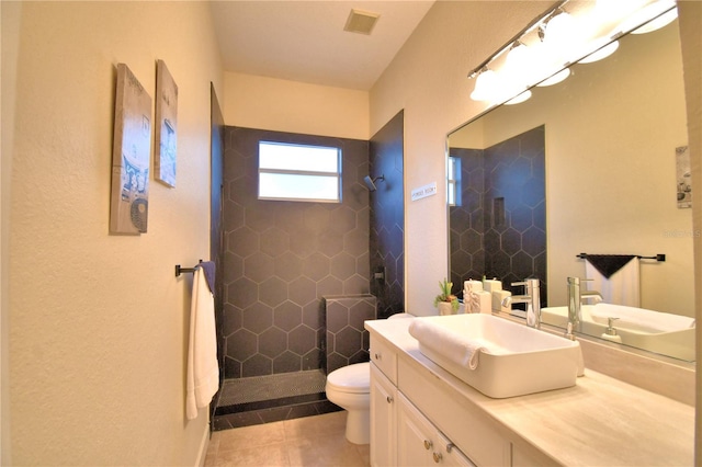 bathroom featuring visible vents, vanity, toilet, and a walk in shower