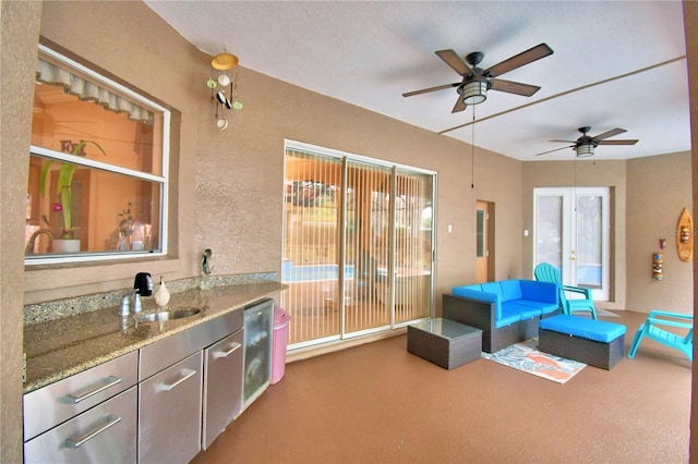 view of patio / terrace with outdoor lounge area, a sink, a ceiling fan, exterior kitchen, and french doors