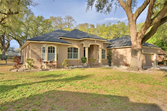 view of front of home with a garage, fence, concrete driveway, stucco siding, and a front yard