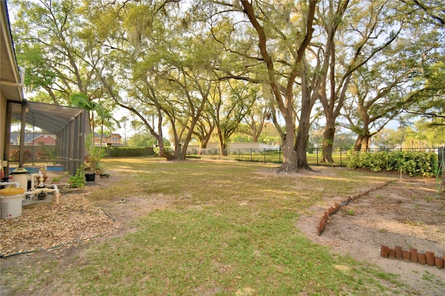 view of yard featuring fence and a lanai