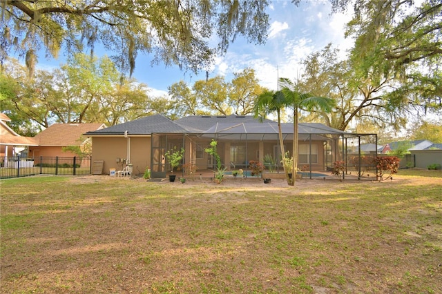 rear view of property featuring glass enclosure, a fenced backyard, a lawn, and stucco siding