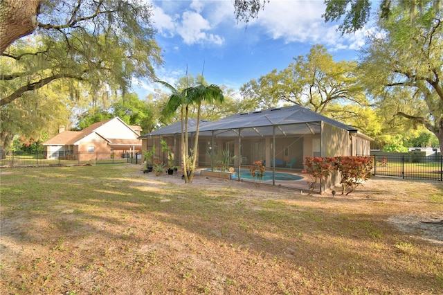 view of yard with fence, a fenced in pool, and a lanai