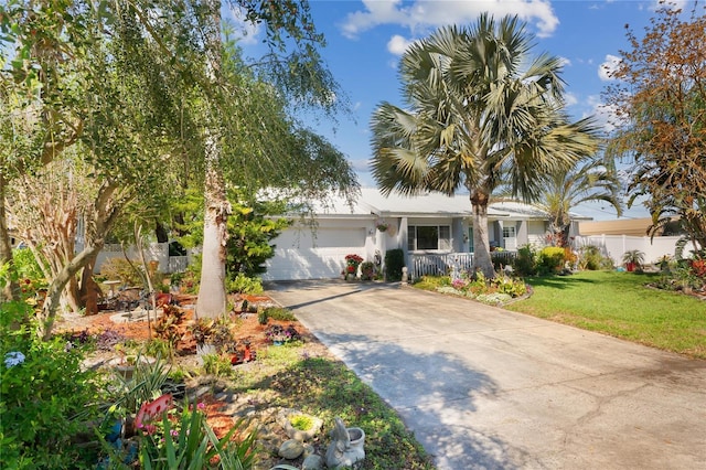 ranch-style home featuring a garage, a front yard, concrete driveway, and fence