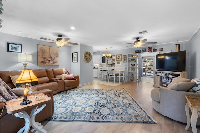 living area featuring recessed lighting, ceiling fan with notable chandelier, visible vents, light wood finished floors, and crown molding