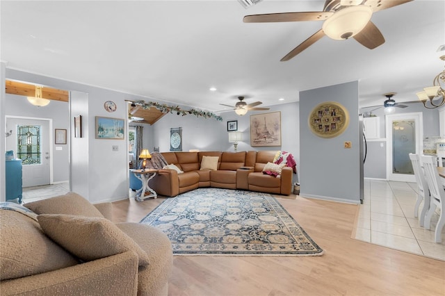 living area with baseboards, light wood finished floors, and recessed lighting