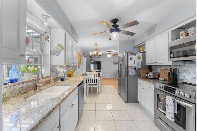 kitchen featuring appliances with stainless steel finishes, white cabinets, and a sink