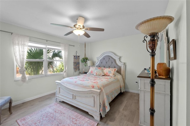 bedroom with light wood-style floors, baseboards, and a ceiling fan