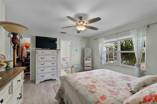 bedroom featuring visible vents, a ceiling fan, a walk in closet, light wood-type flooring, and a closet