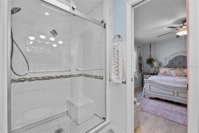 ensuite bathroom featuring a stall shower, ensuite bath, a ceiling fan, and wood finished floors