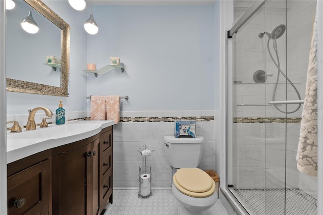 bathroom featuring a stall shower, tile walls, vanity, and toilet