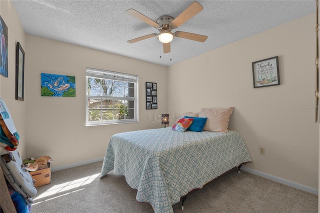 bedroom with carpet floors, a ceiling fan, baseboards, and a textured ceiling