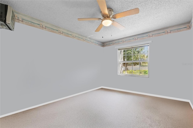 empty room with ceiling fan, baseboards, a textured ceiling, and an AC wall unit