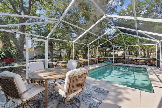 outdoor pool featuring glass enclosure and a patio