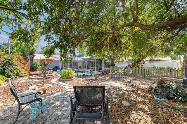 view of patio / terrace featuring glass enclosure and fence