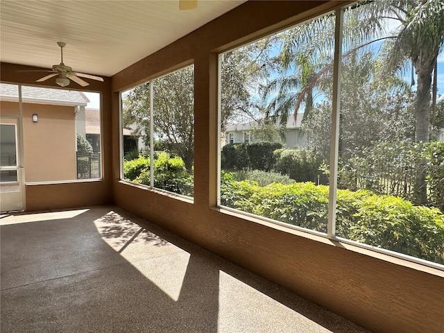 unfurnished sunroom featuring ceiling fan