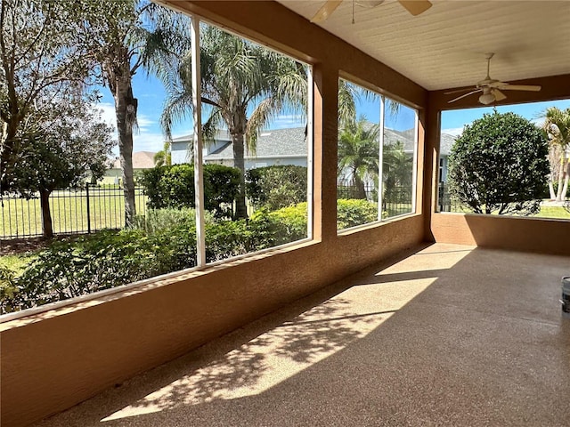 unfurnished sunroom with ceiling fan