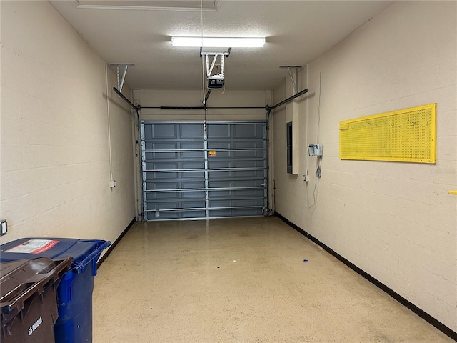 garage featuring concrete block wall and a garage door opener