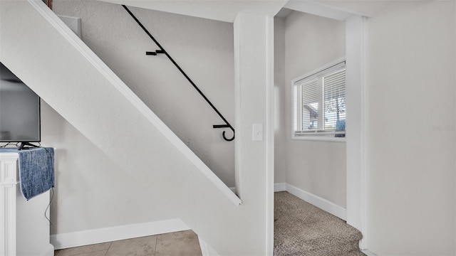 stairs featuring baseboards and carpet flooring