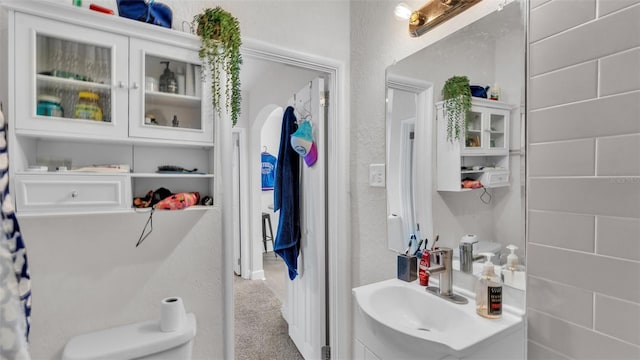 bathroom with a textured wall and vanity