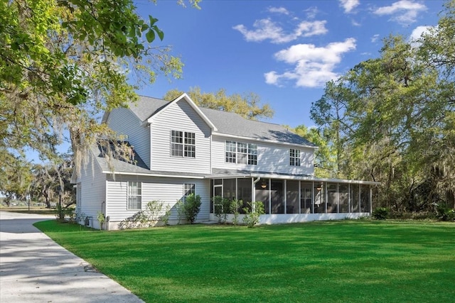 back of house with a yard and a sunroom