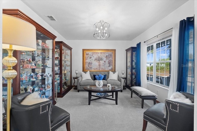 sitting room with carpet, visible vents, and an inviting chandelier