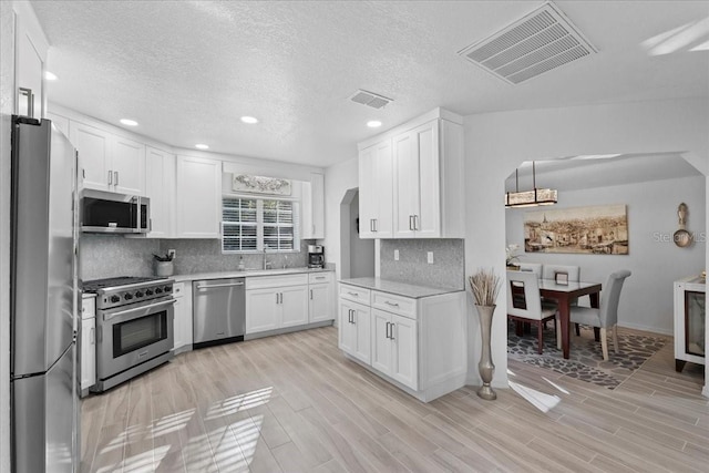 kitchen featuring stainless steel appliances, light countertops, visible vents, and a sink