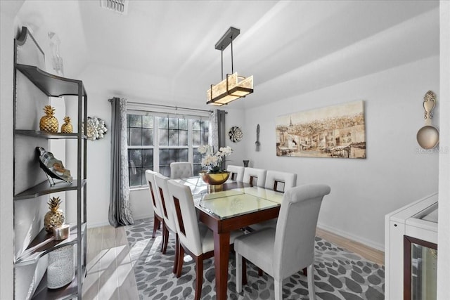 dining area featuring visible vents, baseboards, and wood finished floors