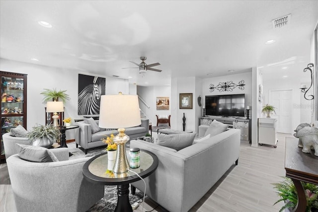 living area featuring light wood-style flooring, a ceiling fan, visible vents, and recessed lighting