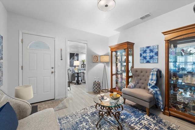 living area with light wood finished floors, baseboards, and visible vents