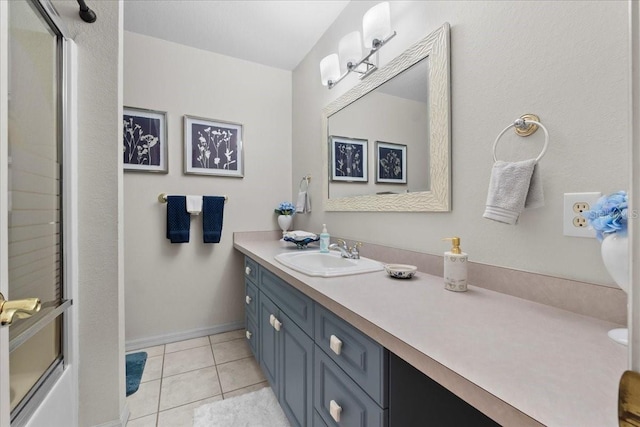 full bath with tile patterned flooring, an enclosed shower, baseboards, and vanity