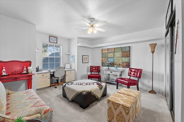 bedroom with a textured ceiling, ceiling fan, and light colored carpet