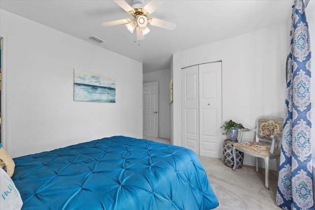 carpeted bedroom featuring a closet, visible vents, and a ceiling fan