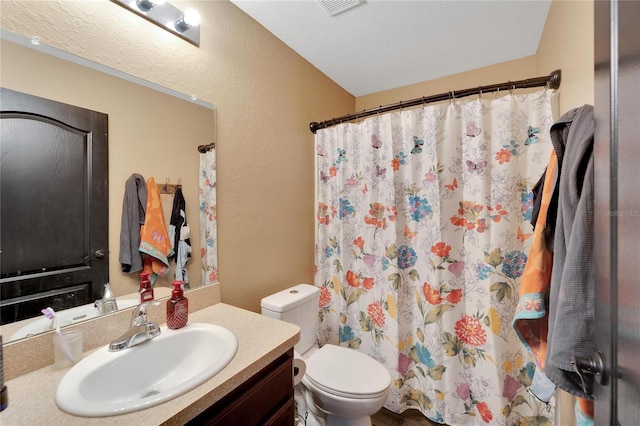 full bathroom with toilet, a textured wall, visible vents, and vanity