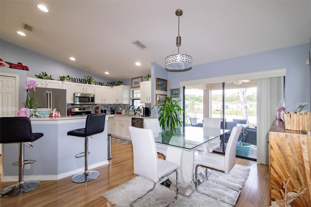 dining room featuring lofted ceiling, recessed lighting, visible vents, and light wood finished floors