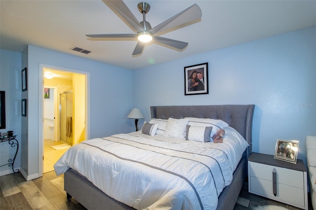 bedroom with ceiling fan, wood finished floors, visible vents, and connected bathroom