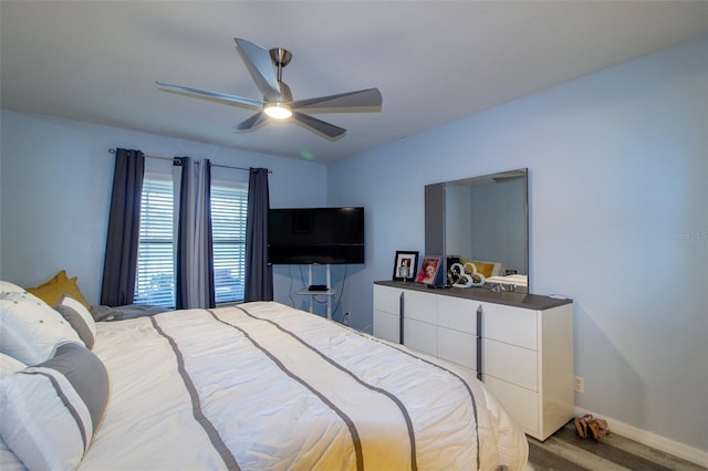 bedroom featuring a ceiling fan, wood finished floors, and baseboards