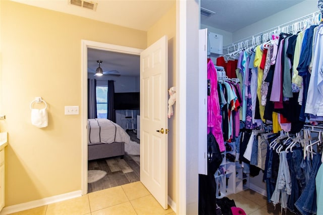 walk in closet with tile patterned floors, visible vents, and ceiling fan