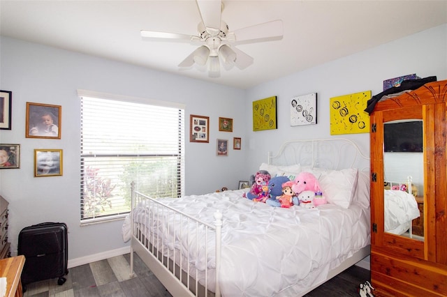 bedroom featuring baseboards, wood finished floors, and a ceiling fan