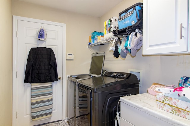 washroom featuring cabinet space and washer and clothes dryer