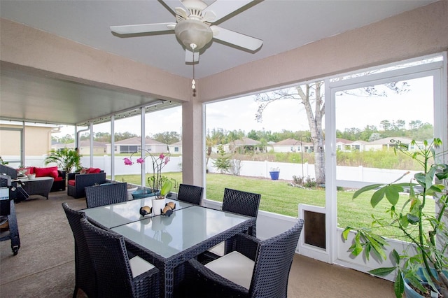 sunroom / solarium featuring a residential view and ceiling fan