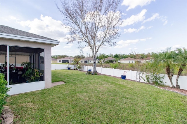 view of yard featuring a fenced backyard and a sunroom