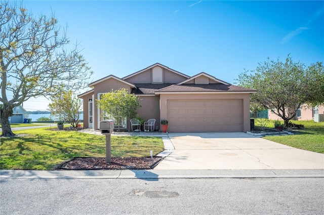 view of front facade with driveway, a garage, a front lawn, and stucco siding