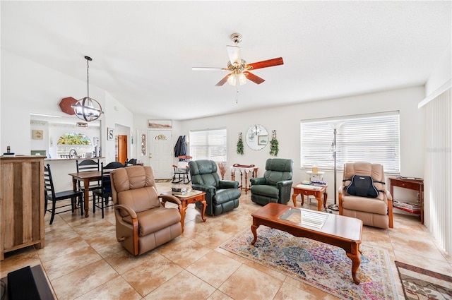 living room featuring light tile patterned floors, vaulted ceiling, and ceiling fan with notable chandelier