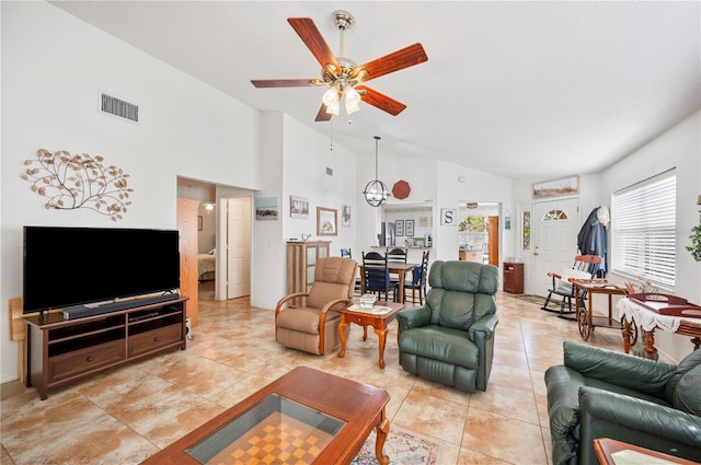 living area with light tile patterned floors, high vaulted ceiling, visible vents, and a ceiling fan