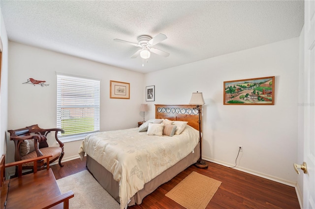 bedroom with a textured ceiling, wood finished floors, and baseboards