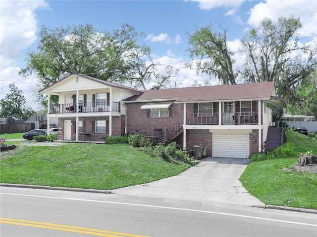 split level home featuring brick siding, a balcony, a garage, driveway, and a front lawn