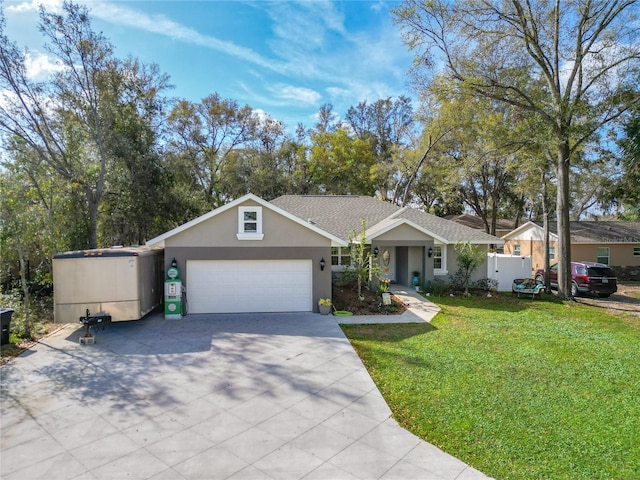 single story home featuring a garage, a front yard, driveway, and stucco siding