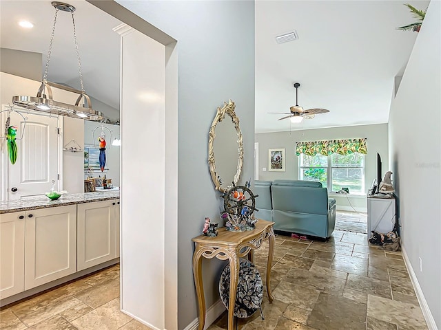 interior space with stone tile floors, visible vents, and baseboards