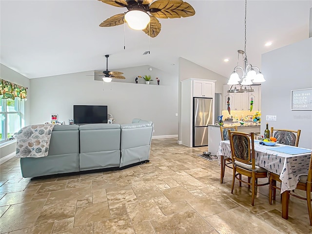 interior space featuring lofted ceiling, stone tile floors, baseboards, and ceiling fan with notable chandelier