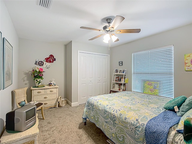 carpeted bedroom featuring ceiling fan, a closet, and visible vents